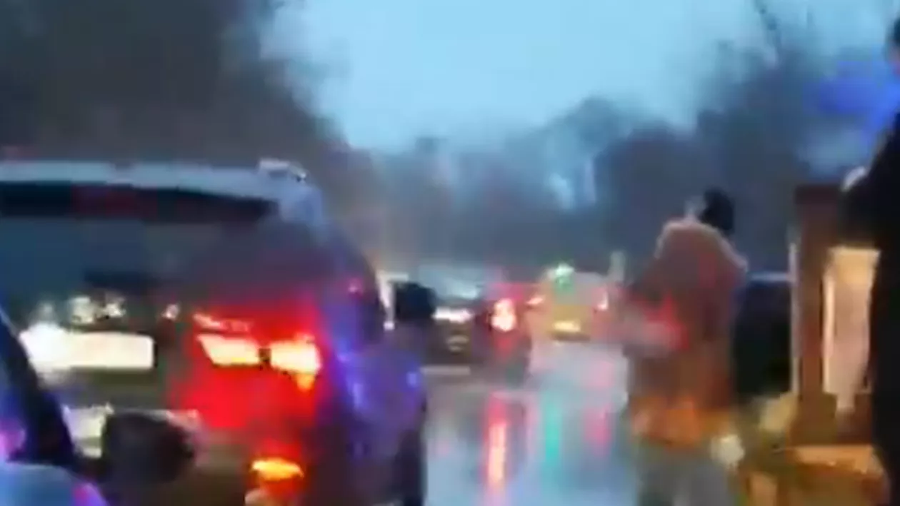 Un preot, surprins când stropea cu agheasmă maşinile din trafic. El se deplasa cu o căruță escortată de o maşină a poliţiei locale (VIDEO)