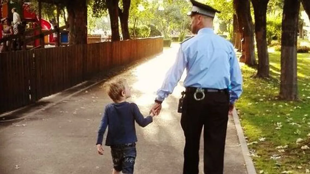 Care este povestea palpitantă din spatele acestei fotografii-simbol: Polițistul care ține de mână un copil pierdut în parc (FOTO)
