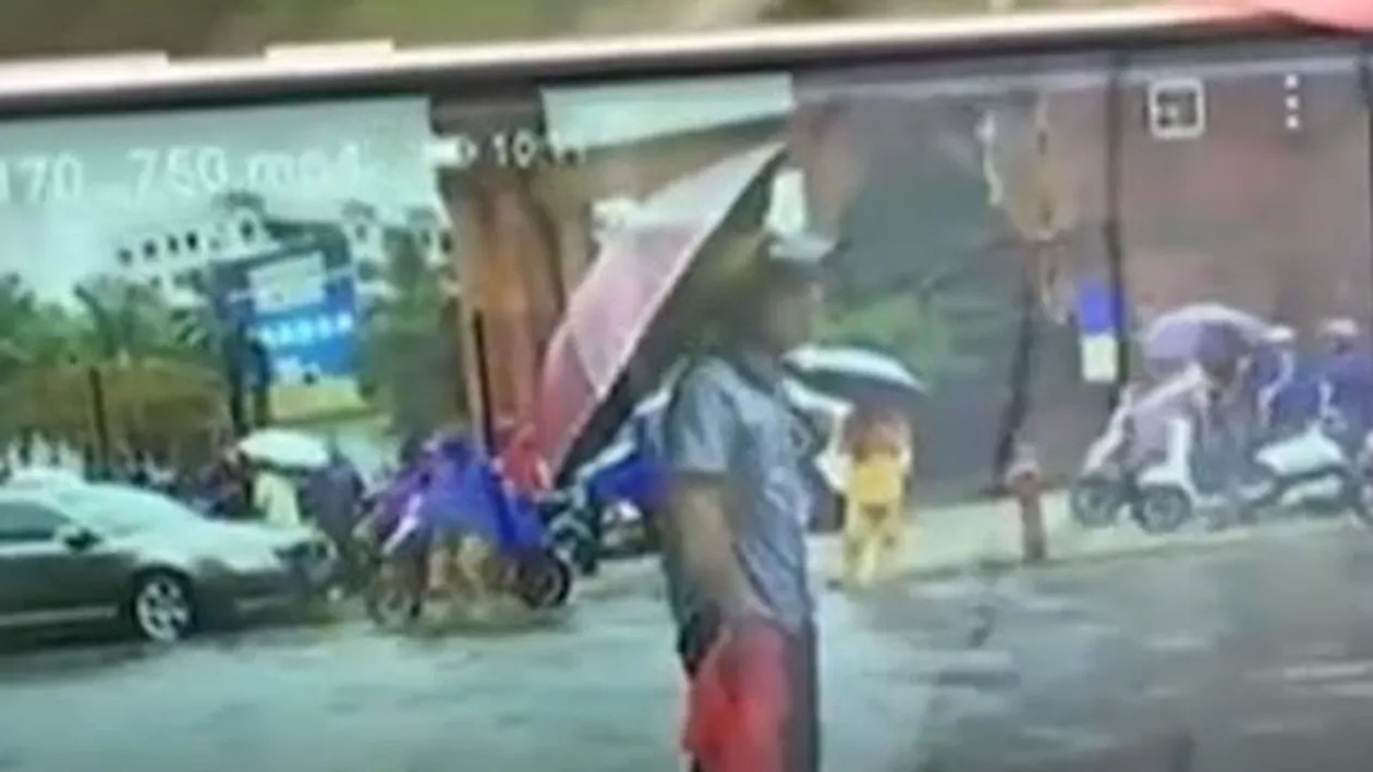 Gest superb făcut de un bărbat pe o ploaie torențială. A stat nemișcat pentru a semnaliza șoferii să ocolească o gură de canalizare (VIDEO)