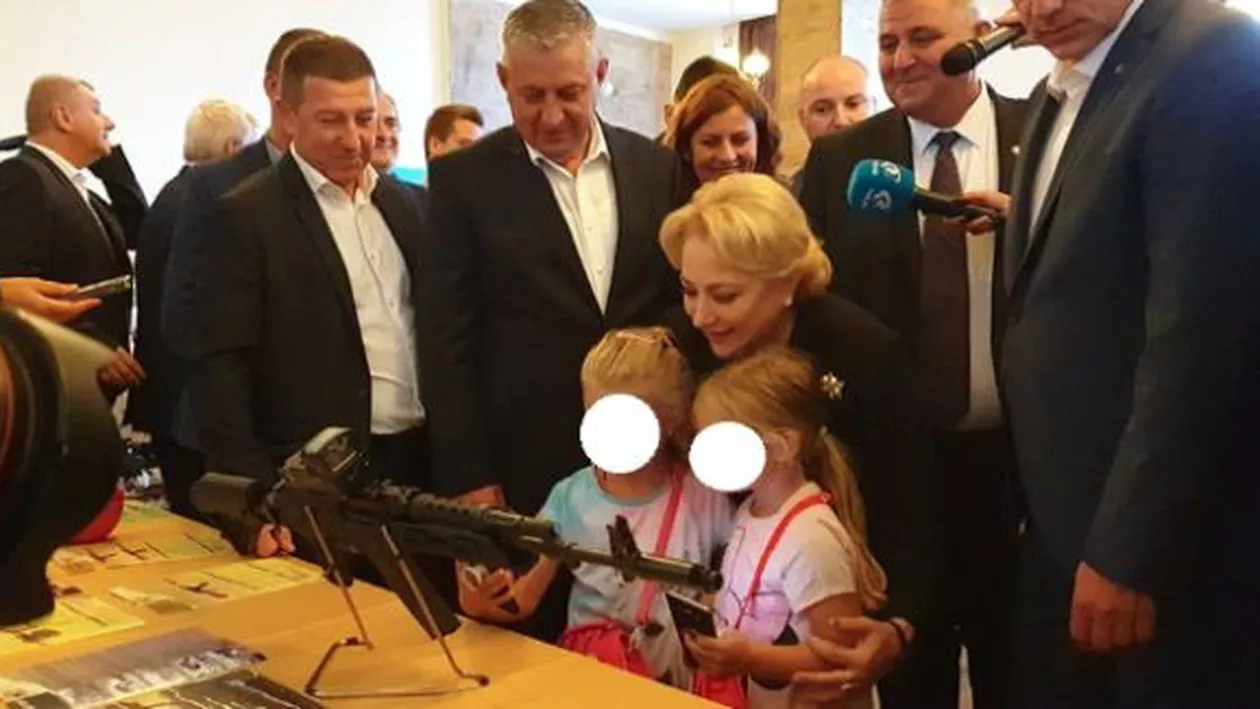 Episod halucinant la Cugir: Premierul Viorica Dăncilă s-a fotografiat cu două fetiţe în timp ce le arată minorelor cum arată o armă de asalt (FOTO)