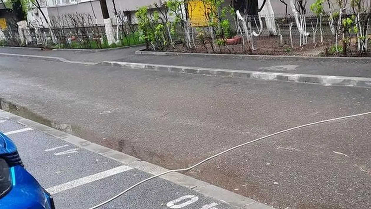 Soluția unui bucureștean pentru a-și încărca mașina electrică mai ieftin: Prelungitorul tras de la etaj, peste stradă (FOTO)