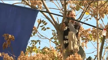 Scene incredibile în fața Tribunalului București: "Stegarul dac" s-a urcat într-un copac pentru a protesta. Acesta a fost luat cu duba după ce a coborât (VIDEO)