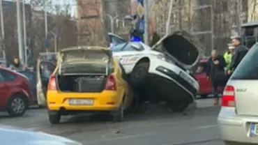 Mașină de poliție răsturnată peste un taxi, pe o stradă din Capitală (FOTO)