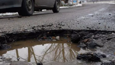 Un șofer din Maramureș și-a rupt maşina în două într-o groapă acoperită cu apă (FOTO)