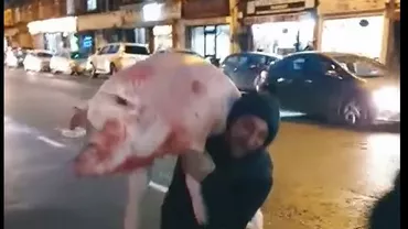 Încă o ispravă a românilor din Marea Britanie: Au tăiat porcul și au defilat cu el prin Londra (VIDEO)