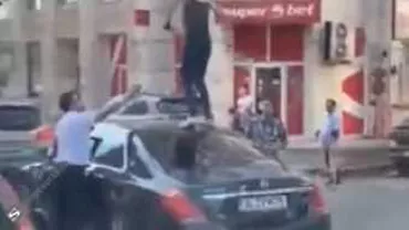 O femeie s-a urcat pe o masină de lux oprită la semafor în Bucureşti şi a început să danseze (VIDEO)