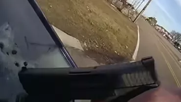 Polițist luat pe capotă de șoferița unei mașini furate. A împușcat-o prin parbriz (VIDEO)